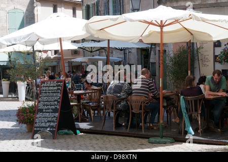 Touristen sitzen außerhalb Restaurants in Place Gambetta, Pezenas, Frankreich. Stockfoto