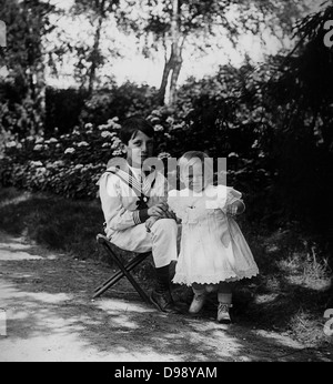 junge französische Kinder spielen im Garten. Um 1900 Stockfoto