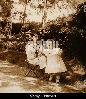 junge französische Kinder spielen im Garten. Um 1900 Stockfoto