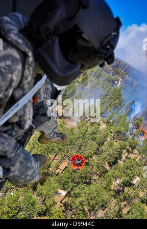 Ein uns Armee UH-60 Black Hawk Hubschrauber trägt einen 500 Gallonen Brandbekämpfung Eimer Wasser auf den Black Forest Fire 12. Juni 2013 in der Nähe von Colorado Spring, CO fallen. Das Feuer hat zwei Menschen getötet und mehr als 500 Häuser immer das zerstörendste Wildfire in Colorado zerstört. Stockfoto