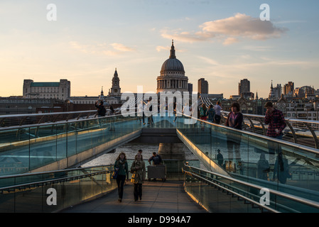 Millennium Bridge mit St Pauls Cathedral London England / LONDON, England – Fußgänger überqueren die Millennium Bridge, eine Stahlbrücke über die Themse, mit der Kuppel der St. Paul's Cathedral im Hintergrund. Die heutige Kathedrale, die von Sir Christopher Wren entworfen wurde, wurde zwischen 1675 und 1710 nach dem Großen Brand von London an einem Ort errichtet, an dem seit 604 n. Chr. eine Kirche untergebracht ist. Die Millennium Bridge wurde 2000 als die erste neue Thames-Kreuzung seit über einem Jahrhundert eröffnet und verbindet London mit der South Bank – Heimat von Tate Modern und Shakespeare's Globe. Stockfoto