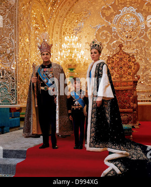 Mohammed Reza Shah Pahlavi (1919-1980) Shah von Iran 1941-1979, mit seiner dritten Frau Farah Diba und ihr Sohn Reza in den zeremoniellen Kleid vor Thron. Stockfoto