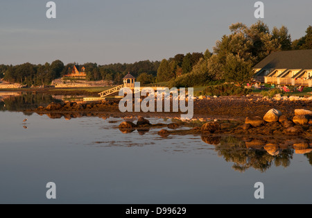 Warmer Sonnenaufgang über eine felsige Küste und Küsten Häuser Stockfoto