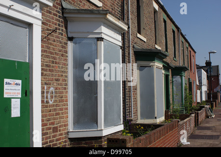 Verfallene Häuser, sicher mit Brettern vernagelt. Eine Straße mit vielen leeren Häusern warten abgerissen werden. Stockfoto