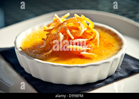 einzelne Portion Creme Brulee garniert mit orange Stockfoto