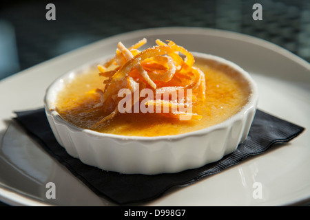 einzelne Portion Creme Brulee garniert mit orange Stockfoto