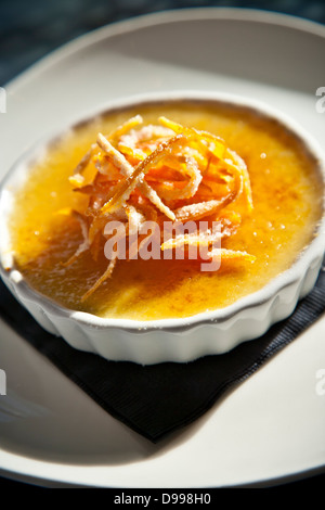 einzelne Portion Creme Brulee garniert mit orange Stockfoto