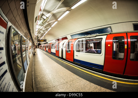 LONDON, Großbritannien – Ein Zug fährt an einem Bahnsteig an einer Londoner U-Bahn-Station ab, die Teil des ausgedehnten U-Bahn-Systems der Stadt ist. Die 1863 eröffnete Londoner U-Bahn ist das älteste U-Bahn-Netz der Welt und bedient täglich Millionen von Fahrgästen im Großraum London. Stockfoto