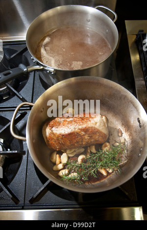 Geschmortes Fleisch in einer Pfanne mit frischen Kräutern und Rotwein Stockfoto