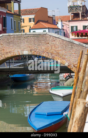 Ziegelbrücke Spaziergang über schmalen Kanal in Burano, Venedig, Italien Stockfoto