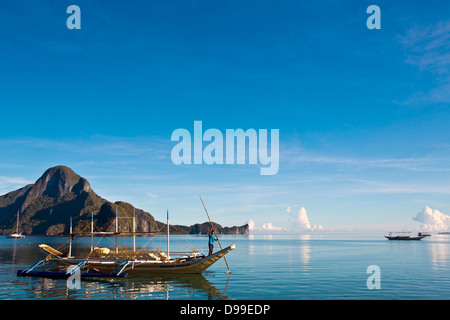 Die Philippinen, Palawan Provinz El Nido, Bootsmann mit Bambusstange. Stockfoto