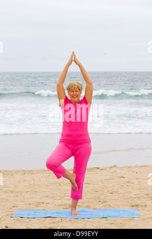 Beautiful senior Woman üben am Strand Stockfoto