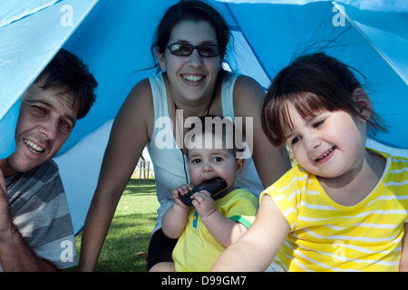 Familie im Park unter Zelt Vordach Stockfoto