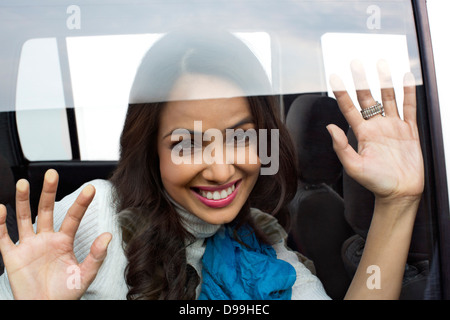 Lächelnde Frau Blick aus Fenster von einem Auto Stockfoto