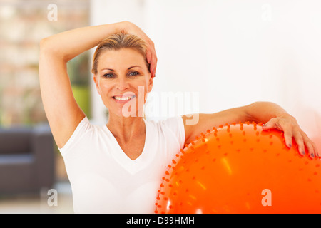 gesunde mittlere gealterte Frau hält Gymnastikball Stockfoto