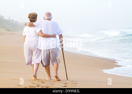 älteres Ehepaar zu Fuß am Strand Stockfoto