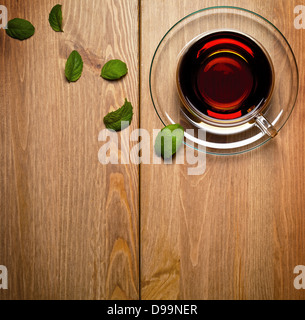 Tee Minze in Glasschale mit frischer Minze auf hölzernen Hintergrund. Ansicht von oben Stockfoto