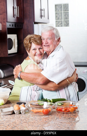 glücklich senior Liebespaar umarmt in Küche Stockfoto