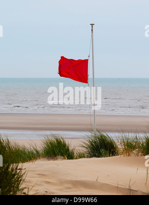 Eine rote Flagge vor gefährlichen Wasser am Strand von Camber Sands, Rye, East Sussex. Stockfoto