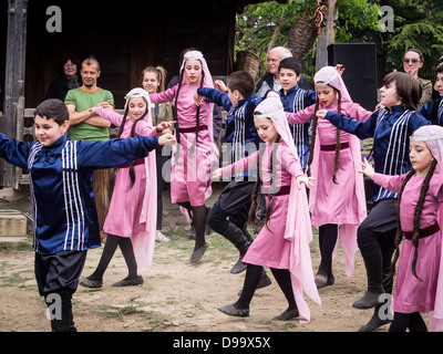 Kinder in traditionellen Kleidern tanzen Volkstänze während der vierten jährlichen Young Weinfest in Tiflis. Stockfoto