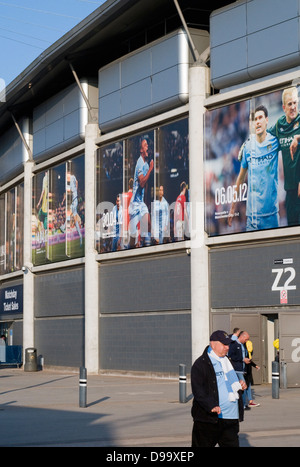 Außenseite des Manchester Citys Etihad Fußballstadion in England, UK, mit Fans, die zu Fuß zu einem Spiel Stockfoto