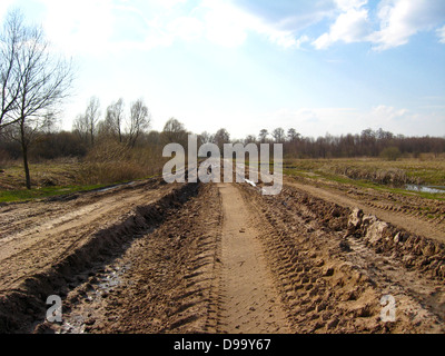 das Bild der Landstraße mit größeren Spuren des Autos und des Schmutzes Stockfoto