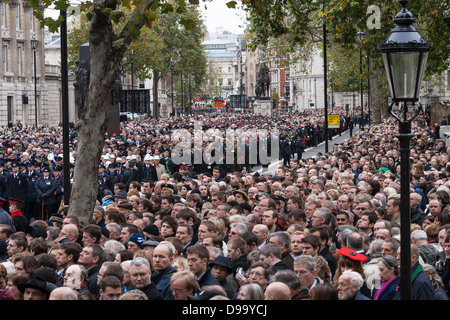 Große Menschenmenge am Ehrenmal in Whitehall, London am Remembrance Day Sonntag mit einer Frau einen Hut unverwechselbaren roten Mohn Stockfoto