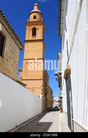 Schmalen ruhigen Kopfsteinpflasterstraße mit Kirchturm in Osuna; Andalusien; Spanien Stockfoto