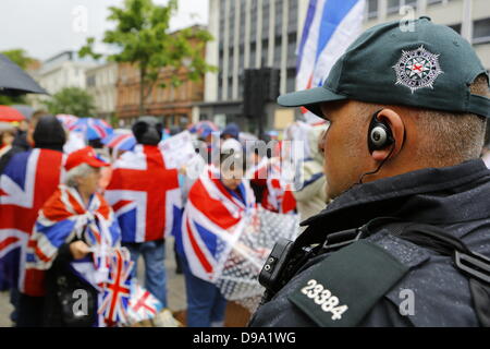 Belfast, Vereinigtes Königreich. 15. Juni 2013. Ein Offizier der Polizei (Police Service of Northern-Ireland) Uhren den Unionisten Protest. Einige Demonstranten Loyalist, viele von ihnen gekleidet mit Union Jacks, ICTU Anti-G8-Protest außerhalb der Belfast City Hall konfrontiert und versucht, es mit Geschrei zu stören. Dank einer starken Polizeipräsenz blieb beiden Protest friedlich. Bildnachweis: Michael Debets/Alamy Live-Nachrichten Stockfoto