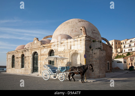 Pferdekutsche neben der türkischen Yiali Tzami (auch bekannt als Giali Tzamisi) Moschee auf der Promenade entlang des venezianischen Hafens in der Altstadt von Chania Stockfoto