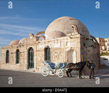 Pferd mit Wagen und Fahrer neben der türkischen Yiali Tzami Moschee am venezianischen Hafen in der Altstadt von Chania Stockfoto