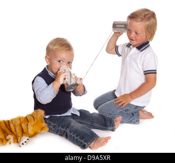 Zwei kleine Brüder, die das Telefonieren mit zwei Dosen und ein Stück Seil Stockfoto