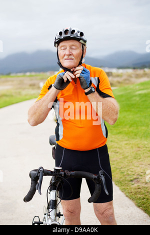 ältere Mann seinen Helm aufsetzen, bevor Sie losfahren Stockfoto