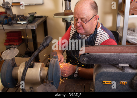 Senior woman mit Schleifmaschine in Werkstatt Stockfoto