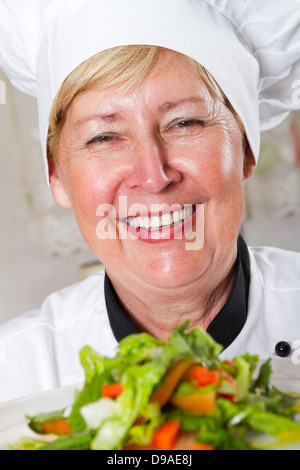 glücklich Seniorchef mit grünem Salat Stockfoto