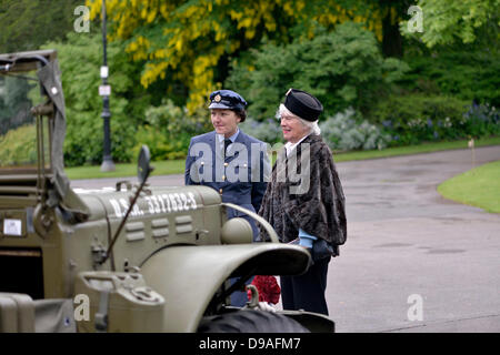 Harrogate, Yorkshire, Großbritannien. 16. Juni 2013. Eine Frau in einem RAF-Uniform und eine Frau im 40er Jahre Kleid bewundern ein Militärfahrzeug der USA bei einer Veranstaltung in Valley Gardens um Geld für die Magnesia Well Pump Room Project, eine Ausstellung auf Mineralquellen zu erstellen. Bildnachweis: John Fryer/Alamy Live-Nachrichten Stockfoto