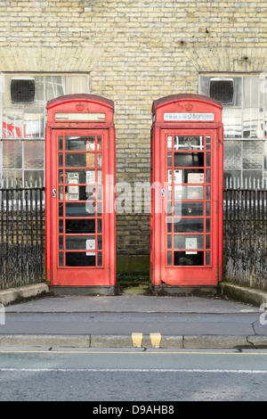 Paar verwüstet aus alten roten Telefonzellen UK Stockfoto