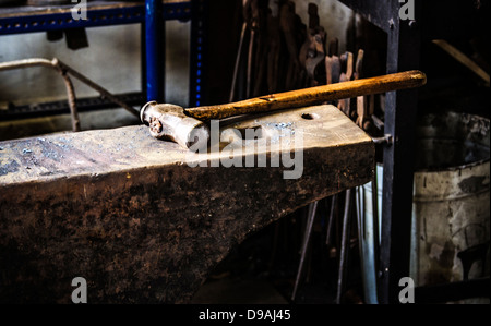 Nahaufnahme von einem Hammer auf einen Amboss in einer Schmiede-Werkstatt Stockfoto