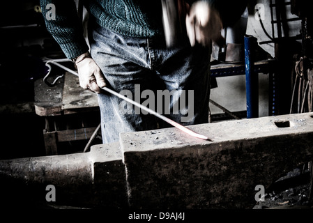 Nahaufnahme von einem Schmied Hämmern heiße Metall auf einem Amboss Stockfoto