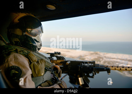 Ein US Marine Corps Crewchief mit der 773rd Marine Licht Angriff Hubschrauberstaffel scannt seine Sektor während einer nahe Luft-Unterstützung-Mission an Bord der UH-1N Huey 25. April 2013 in Hurlburt Field, FL. Stockfoto