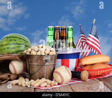 Picknick-Tisch bereit für ein Fourth Of July-fest. Kaltes Bier in einem Uncle Sam Hut, Wassermelone Erdnüsse und Baseball Ausrüstung. Stockfoto