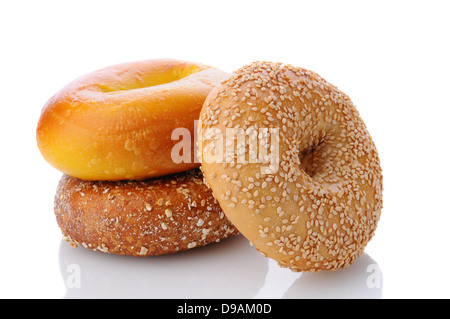 Drei verschiedene Bagels auf einer weißen Fläche mit Reflexion. Jeweils ein Ei Bagel, Sesam und Multi-Korn Stockfoto