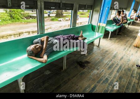 Yangon, Union von Myanmar. 15. Juni 2013. Ein Mann schläft auf dem Beifahrersitz auf den kreisförmigen Zug von Yangon. Die Yangon kreisförmigen Bahn ist das lokale Pendler Schienennetz, das das Stadtgebiet von Yangon dient. Von Myanmar Railways betrieben, verbindet die 45,9 km (28,5 mi) 39-Station-Loop-System Satellitenstädte und vorstädtischen Gebieten in die Stadt. Die Bahn hat rund 200 Trainer, 20 Mal läuft und täglich 100.000 bis 150.000 Tickets verkauft. Die Schleife, die etwa drei Stunden dauert, ist ein beliebtes für Touristen zu sehen, einen Querschnitt des Lebens in Yangon. Die Züge von 03:45, 22:15 Stockfoto