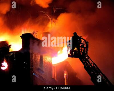 Feuerwehrleute versuchen, ein großes Feuer in einem Haus in Tangermünde, Deutschland, 16. Juni 2013 auszulöschen. Rund 120 Personen der Feuerwehr versucht, die Flammen brennen in den Dachstuhl für mehrere Stunden anhalten. Die Ursache des Feuers ist noch unklar. Foto: Roberto Abramowski Stockfoto