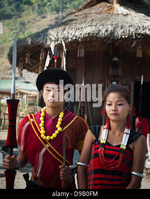 Naga Stammes paar in traditioneller Kleidung vor einer Hütte stehen Hornbill Festival, Kohima, Nagaland, Indien Stockfoto