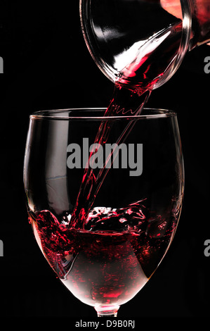 Rotwein in ein Glas aus einer Karaffe gießen Stockfoto