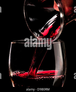 Rotwein in ein Glas aus einer Karaffe gießen Stockfoto