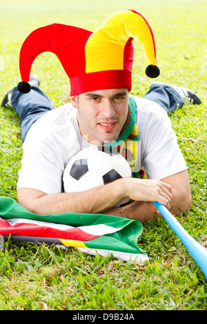 Fußball-Fan, liegend auf dem grünen Rasen Stockfoto