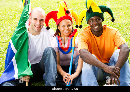 Gruppe von Fußball-Fans auf dem Rasen sitzen Stockfoto