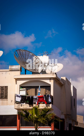 Satellitenschüsseln und Antennen auf dem Dach der weiß gerenderten Wohnung in Zypern Stockfoto